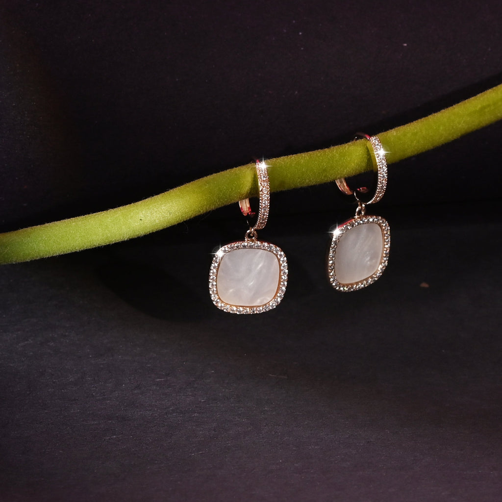 Pair of earrings with a red flower on a dark background