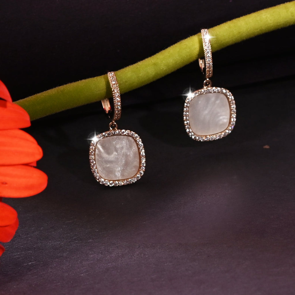 Pair of earrings with a red flower on a dark background